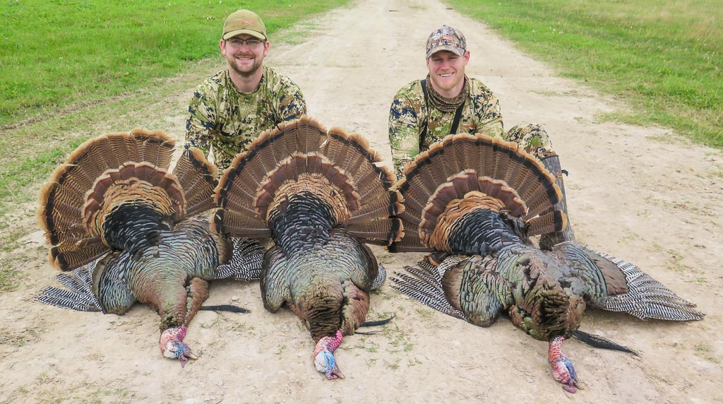 Two hunters pictured with three harvested turkeys in Texas.