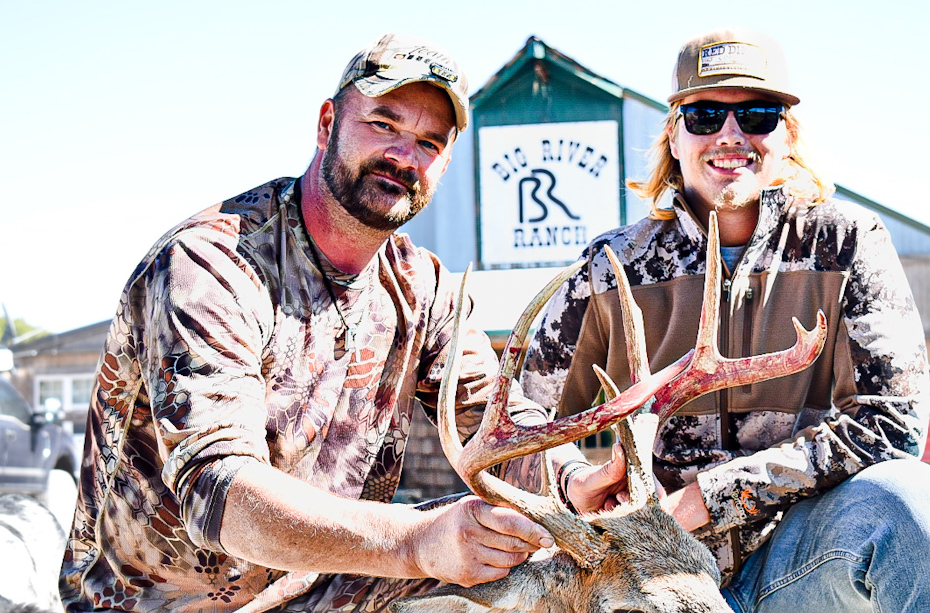 Two hunters pictured with whitetail deer on a Missouri private farm.