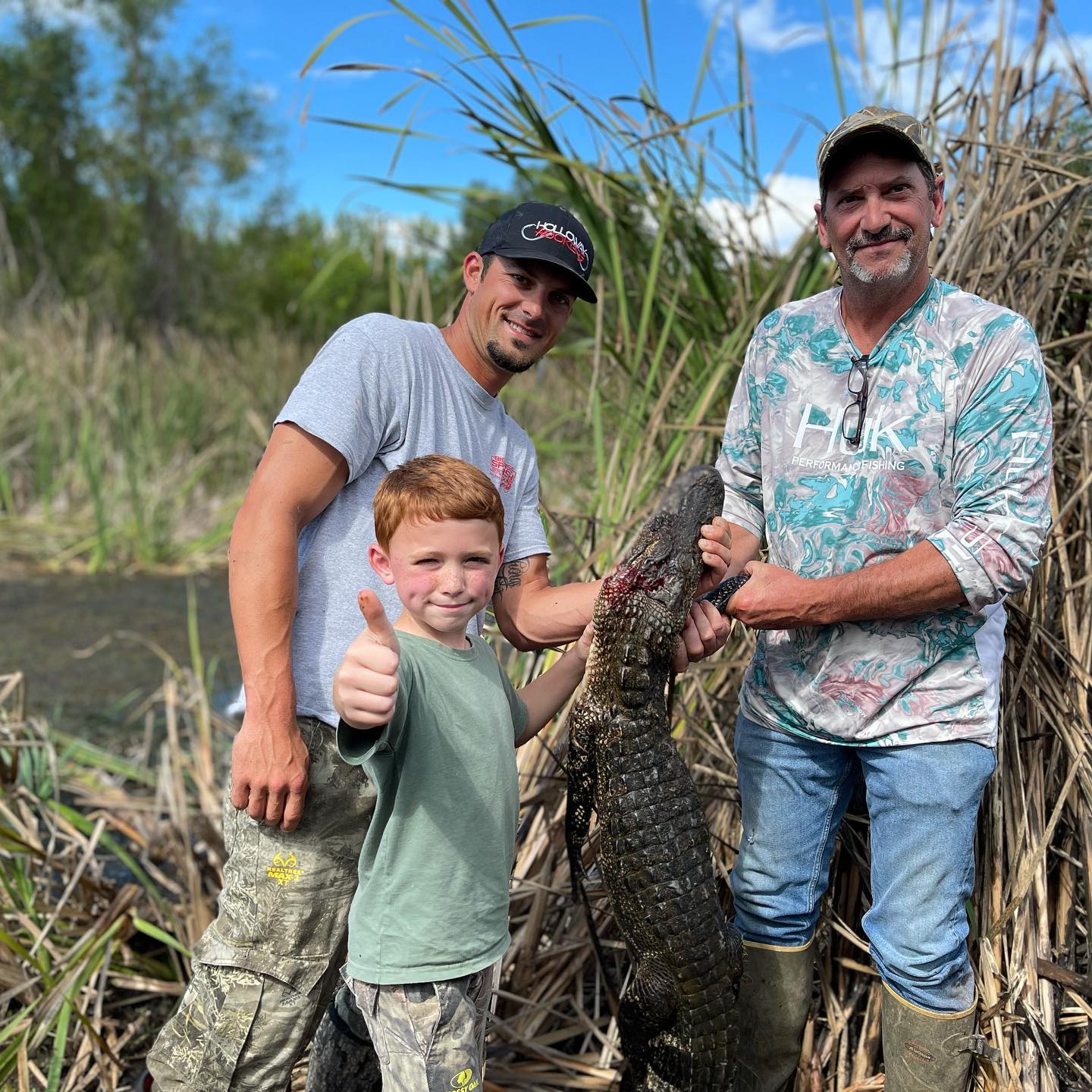 Two men and a child shown with a gator harvested during Louisiana's gator season